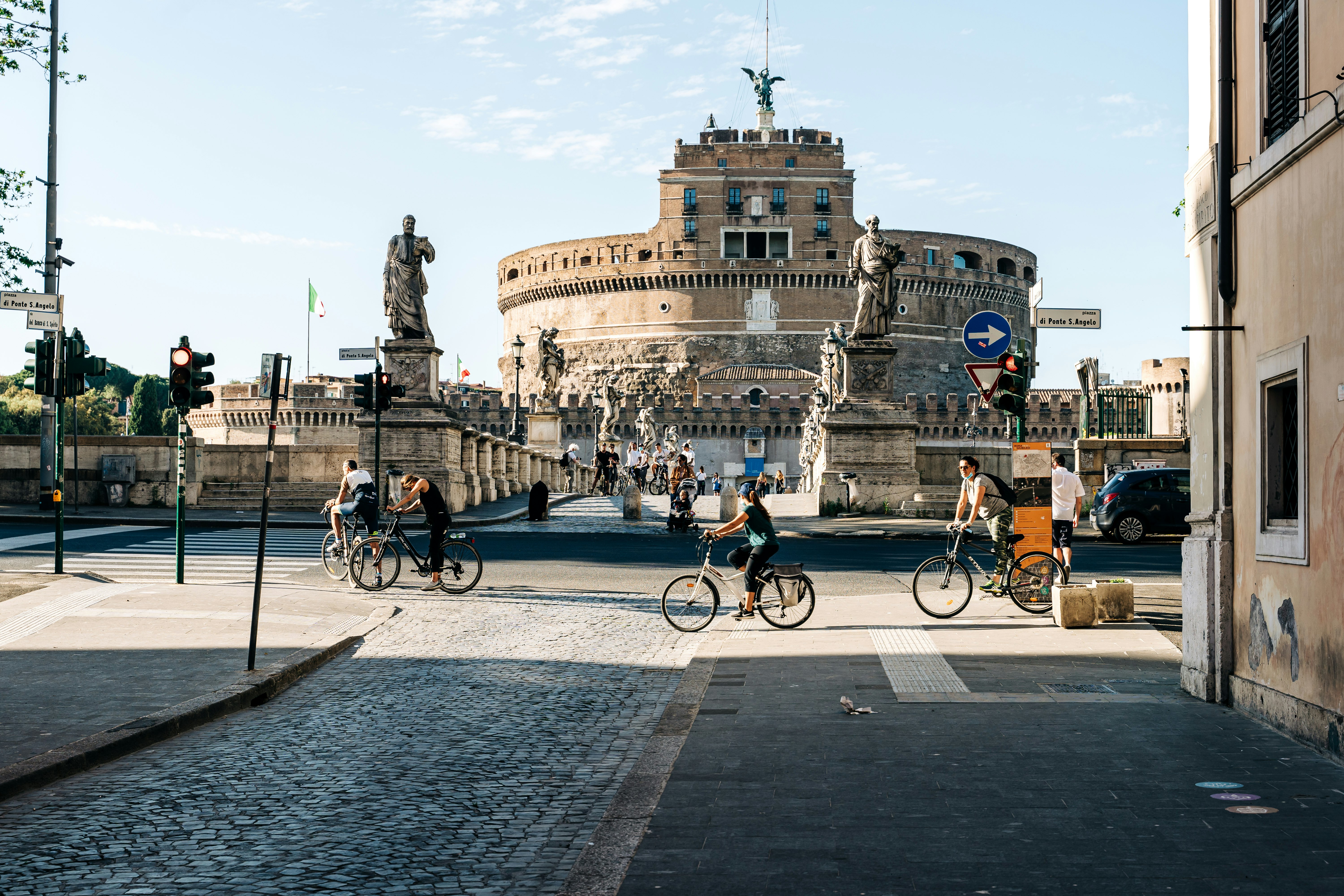 people riding bicycle on road near concrete building during daytime